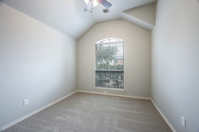 carpeted spare room featuring lofted ceiling, baseboards, visible vents, and a ceiling fan