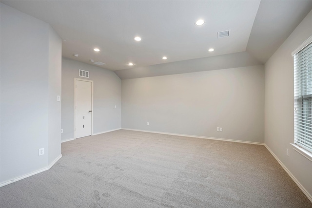 carpeted empty room featuring baseboards, visible vents, vaulted ceiling, and recessed lighting