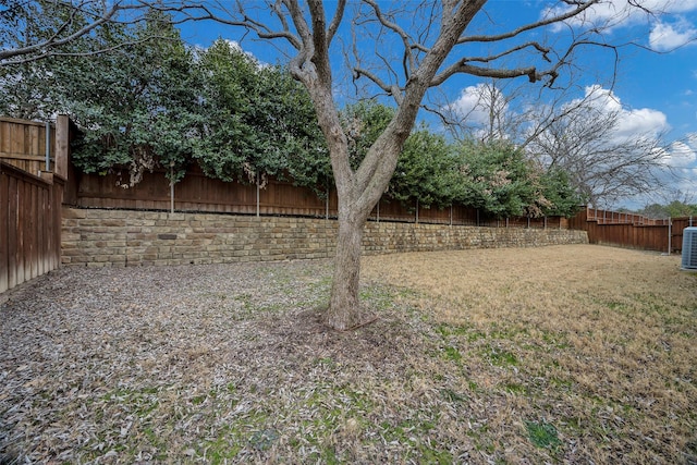 view of yard featuring central AC unit and a fenced backyard