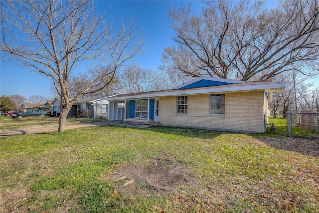 view of front of property with a front yard, fence, and brick siding