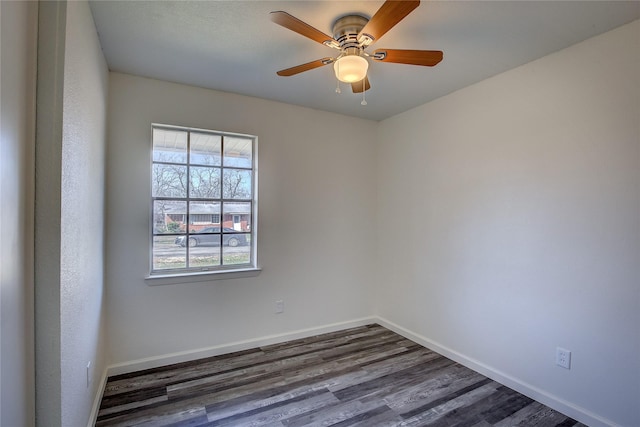 unfurnished room featuring dark wood-type flooring, ceiling fan, and baseboards