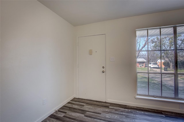 foyer entrance with dark wood-type flooring, plenty of natural light, and baseboards