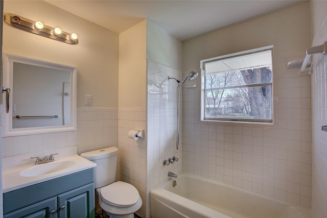 full bathroom featuring tile walls, shower / bathing tub combination, toilet, wainscoting, and vanity