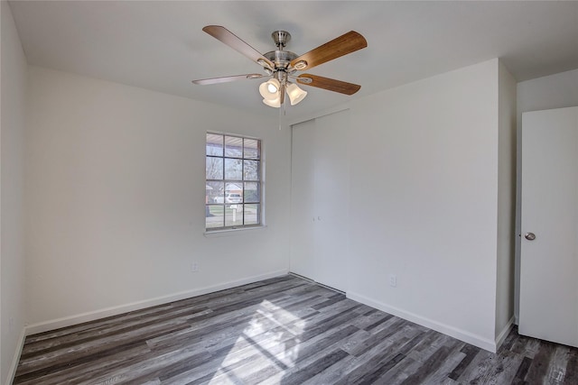 unfurnished room with dark wood-style flooring, ceiling fan, and baseboards