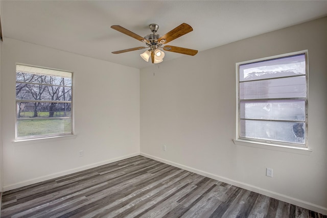 empty room with a ceiling fan, baseboards, and dark wood-type flooring