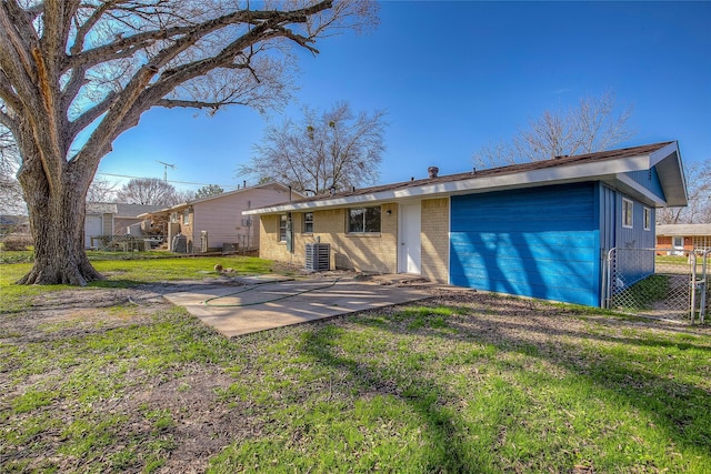 back of house with a yard, a patio area, brick siding, and fence