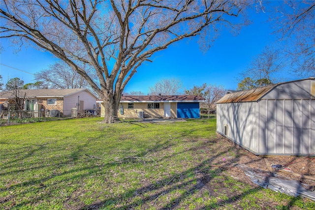 view of yard featuring an outbuilding, fence, and a storage shed