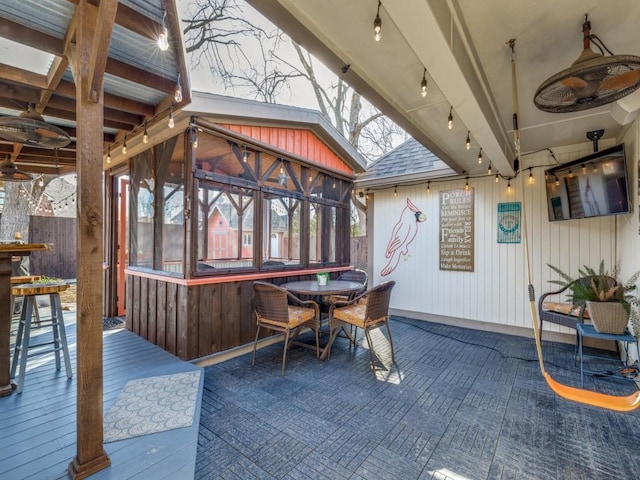 view of patio with a deck, outdoor dining space, and a sunroom