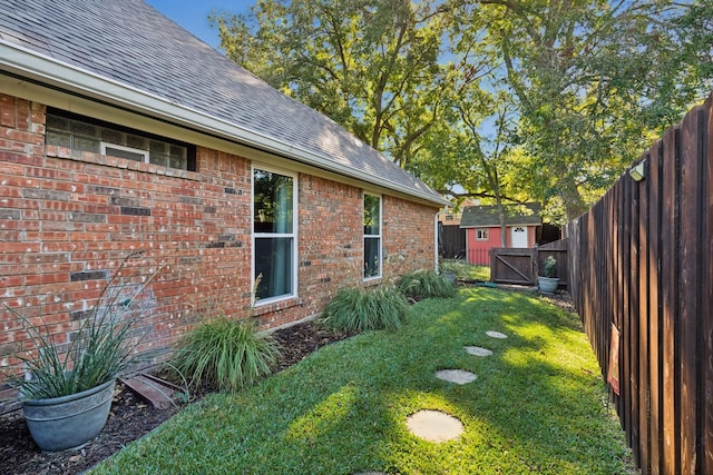 view of yard featuring a shed, an outdoor structure, and a fenced backyard