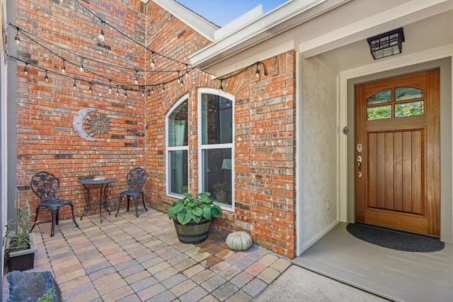 entrance to property featuring brick siding