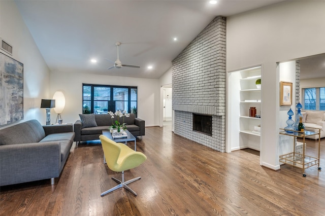 living area featuring baseboards, ceiling fan, wood finished floors, a fireplace, and high vaulted ceiling