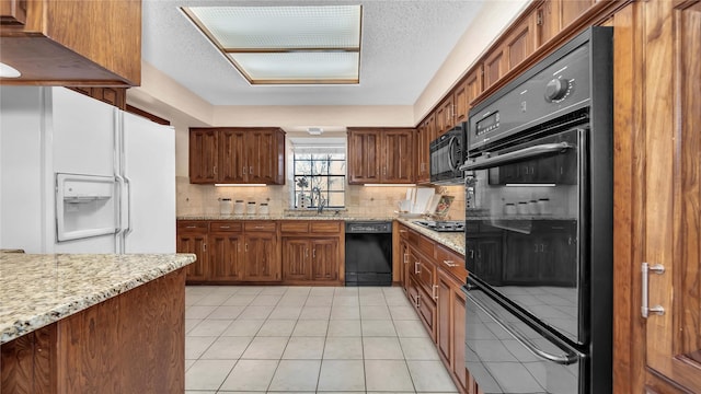 kitchen with black appliances, tasteful backsplash, light tile patterned floors, and a sink