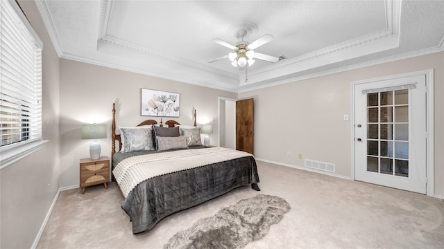 bedroom with baseboards, visible vents, a raised ceiling, ornamental molding, and carpet flooring