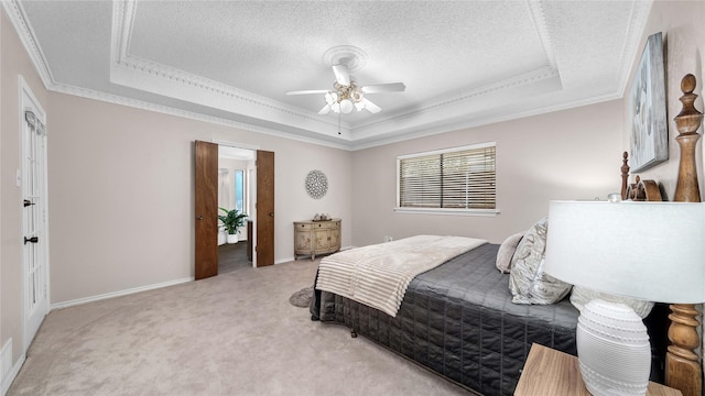 bedroom with light carpet, crown molding, a tray ceiling, and a textured ceiling