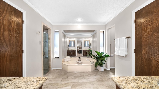 bathroom featuring vanity, baseboards, a bath, a stall shower, and crown molding