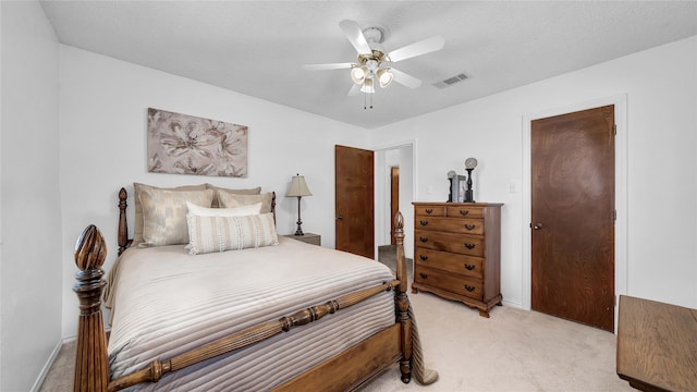 bedroom featuring light carpet, baseboards, visible vents, ceiling fan, and a textured ceiling