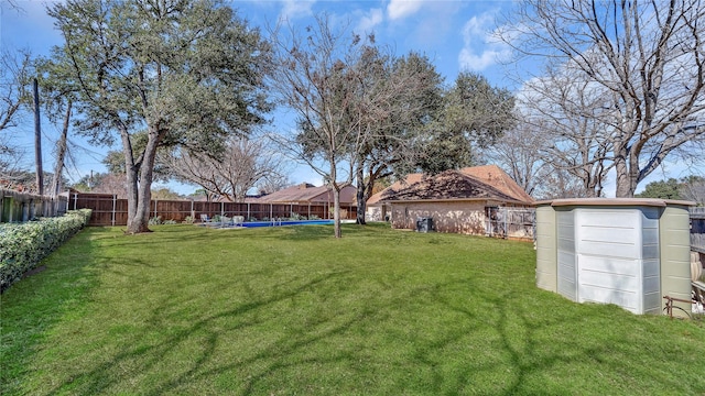 view of yard featuring a fenced backyard, an outdoor structure, and a storage unit