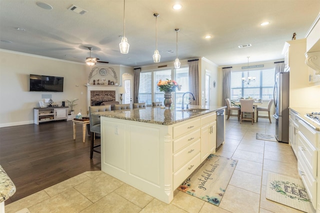 kitchen featuring stainless steel appliances, ornamental molding, a sink, and visible vents