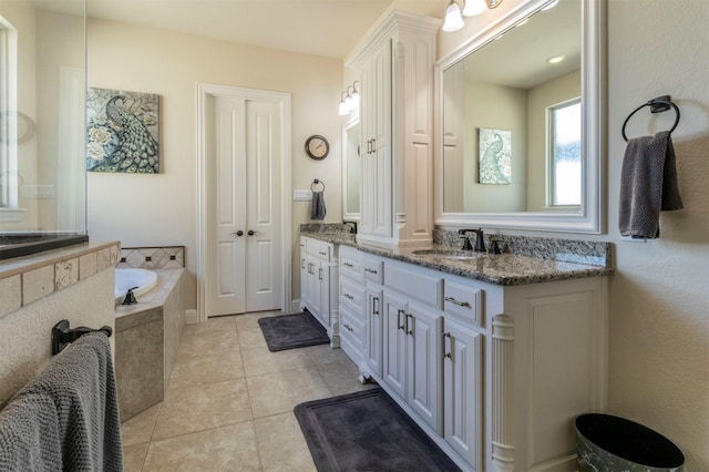 full bath featuring vanity, a bath, and tile patterned floors