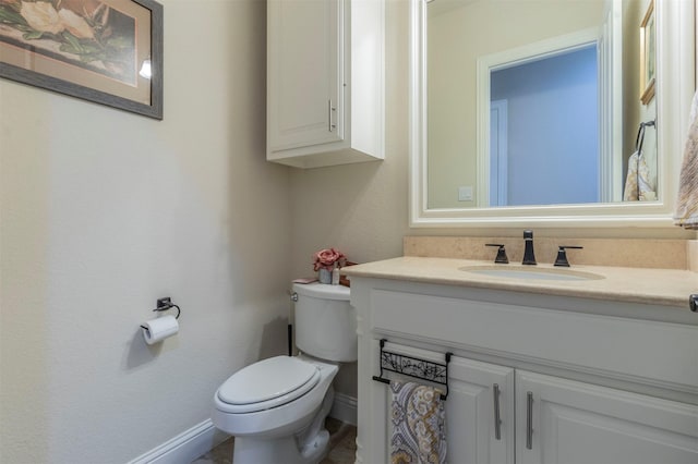 half bath with vanity, toilet, and baseboards