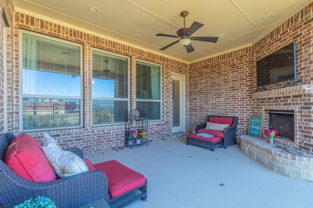 view of patio / terrace with ceiling fan and an outdoor living space with a fireplace