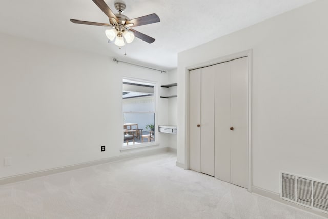 unfurnished bedroom with baseboards, visible vents, a ceiling fan, carpet floors, and a closet