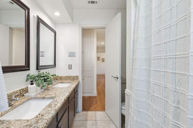 full bathroom with tile patterned flooring, visible vents, a sink, and double vanity