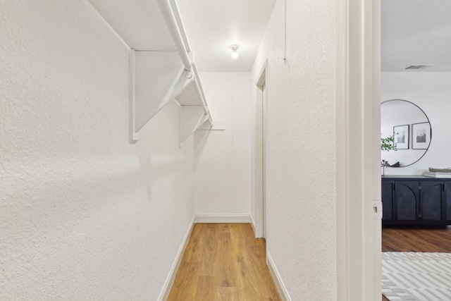 walk in closet with visible vents and wood finished floors