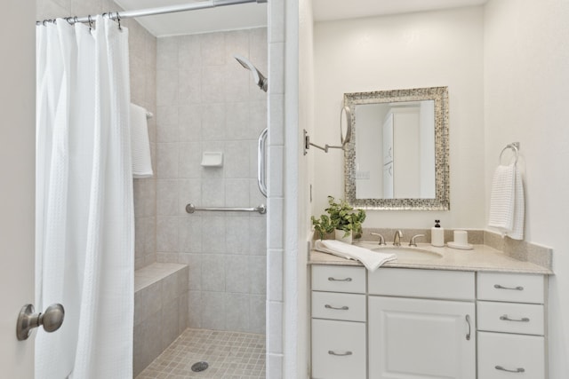 full bath with a tile shower and vanity