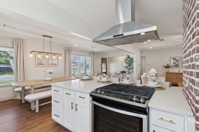 kitchen with visible vents, open floor plan, white cabinetry, stainless steel gas range oven, and exhaust hood