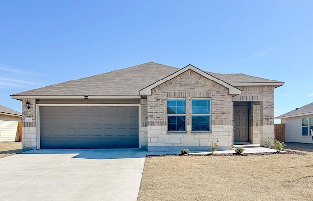 ranch-style house featuring driveway, stone siding, an attached garage, and roof with shingles