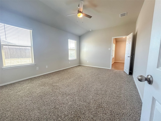 unfurnished room with baseboards, visible vents, a ceiling fan, vaulted ceiling, and carpet floors