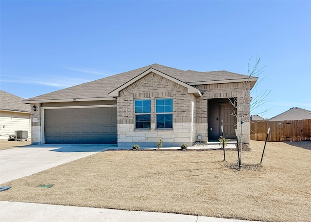 view of front of house featuring driveway, stone siding, an attached garage, fence, and brick siding