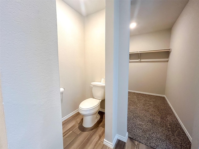 bathroom featuring baseboards, toilet, and wood finished floors