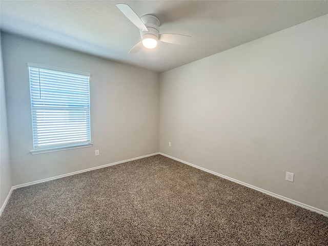 carpeted empty room featuring a ceiling fan and baseboards