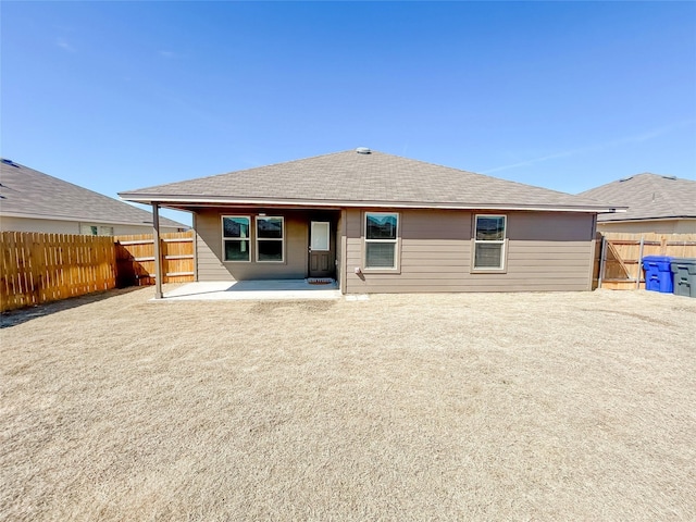 back of house featuring a shingled roof, a patio area, and fence