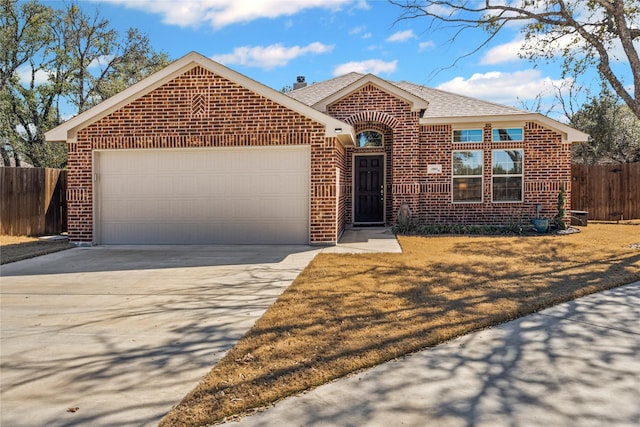 single story home featuring concrete driveway, brick siding, fence, and an attached garage