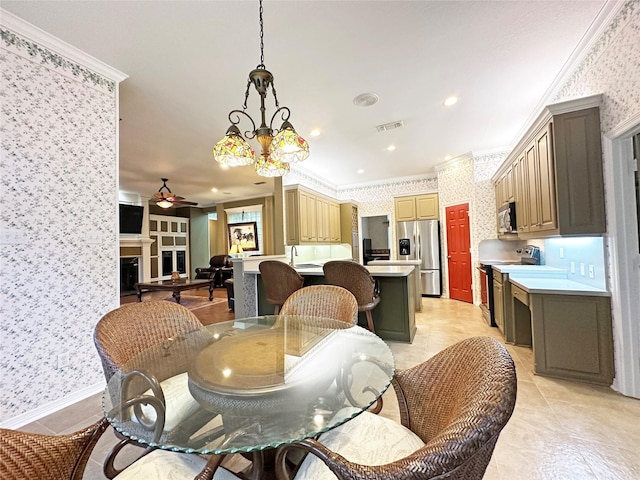 dining space featuring wallpapered walls, a fireplace, and ornamental molding