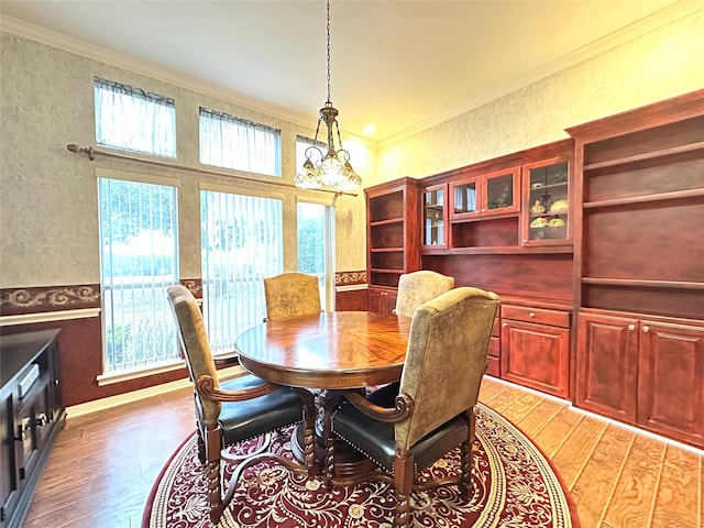 dining room with plenty of natural light, ornamental molding, and light wood-type flooring