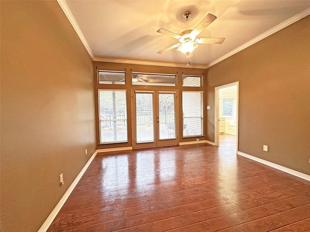 empty room featuring a wealth of natural light, crown molding, and hardwood / wood-style flooring