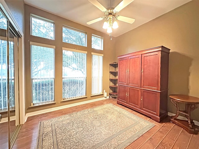 interior space with a ceiling fan, light wood-style flooring, and baseboards