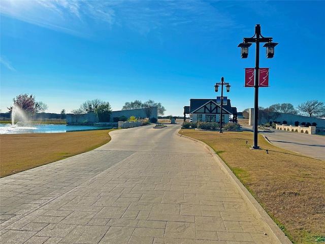 surrounding community featuring a water view and a lawn