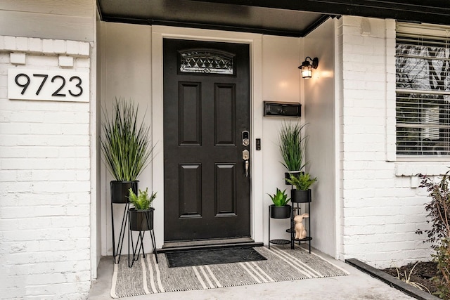 9723 Queenswood Ln, Dallas, TX 75238 - doorway to property featuring brick siding and a porch