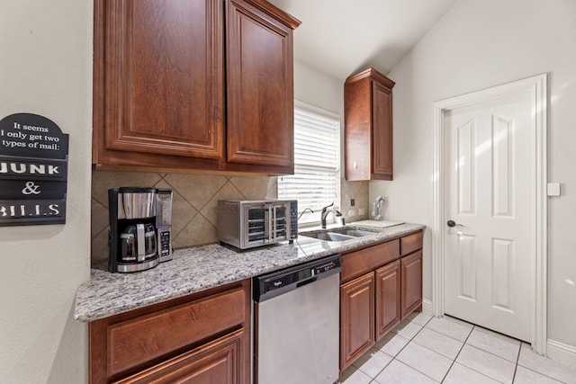 kitchen with dishwasher, tasteful backsplash, light tile patterned floors, and a sink