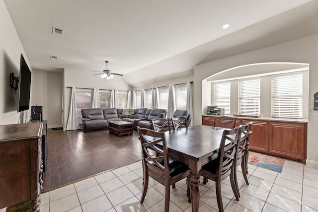 dining area with lofted ceiling, light tile patterned flooring, visible vents, and a ceiling fan