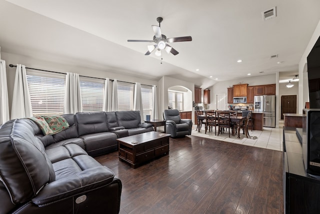 living room with lofted ceiling, light wood finished floors, plenty of natural light, and visible vents