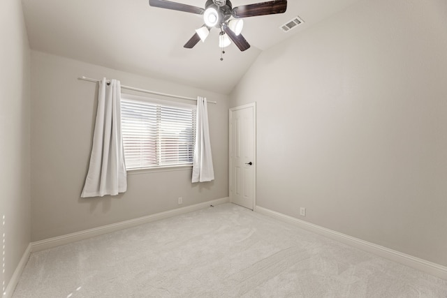 carpeted spare room featuring lofted ceiling, a ceiling fan, visible vents, and baseboards