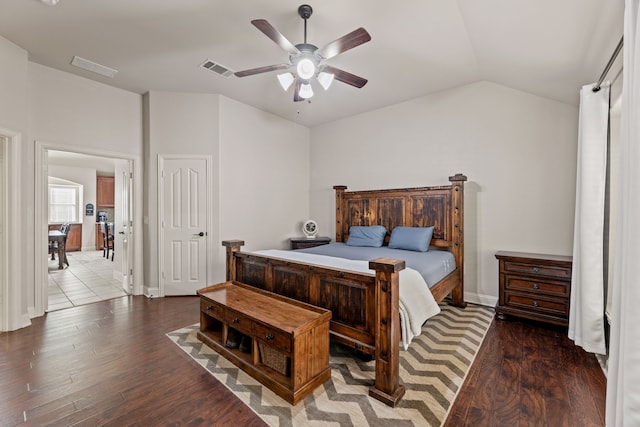 bedroom with baseboards, visible vents, lofted ceiling, ceiling fan, and wood finished floors