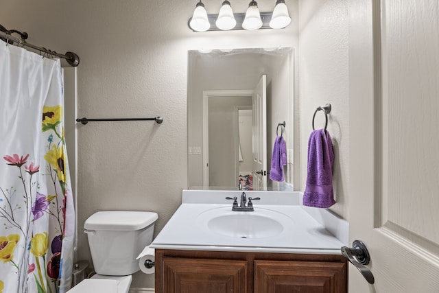 full bathroom with toilet, a textured wall, a shower with shower curtain, and vanity