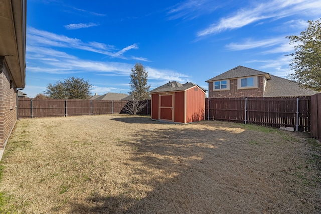 view of yard featuring a fenced backyard, an outdoor structure, and a shed